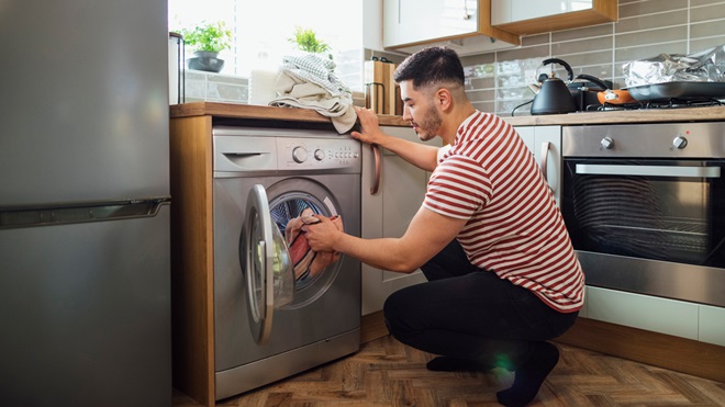 person using a front loader washing machine
